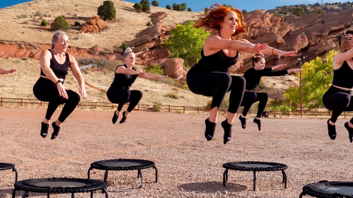 Mujeres saltando en unos trampolines suspendidas en el aire